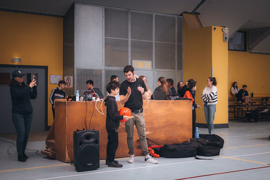 Group of people gathered indoors at an event, interacting and taking photos.